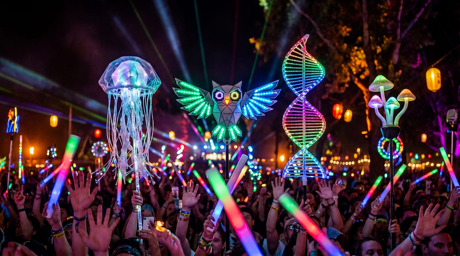 Glowing LED totems held high above a festival crowd at night